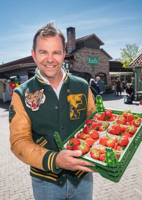 Robert Dahl mit frischen Erdbeeren Robert Dahl hält frische Erdbeeren vor dem Eingang von Karls Erlebnis-Dorf in Rövershagen.
