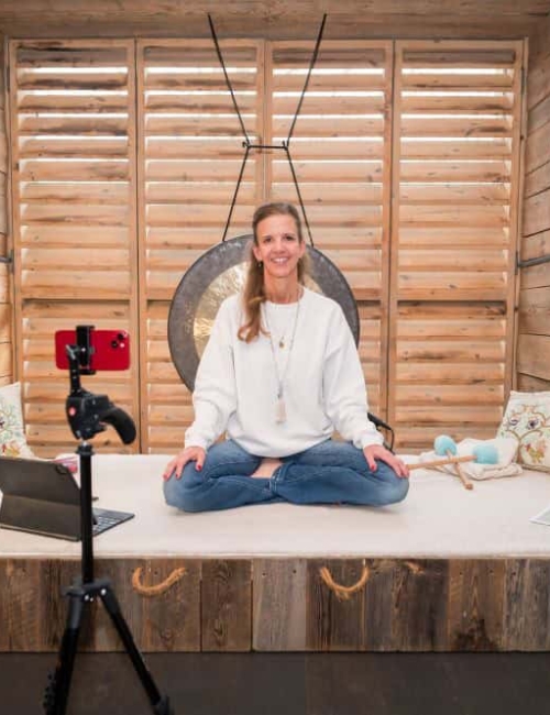 Stephanie Dahl gibt Yogakurse Stephanie Dahl sitzt lächelnd im Schneidersitz für Yoga auf einer Decke.