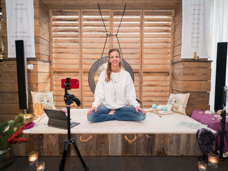 Stephanie Dahl gibt Yogakurse Stephanie Dahl sitzt lächelnd im Schneidersitz für Yoga auf einer Decke.