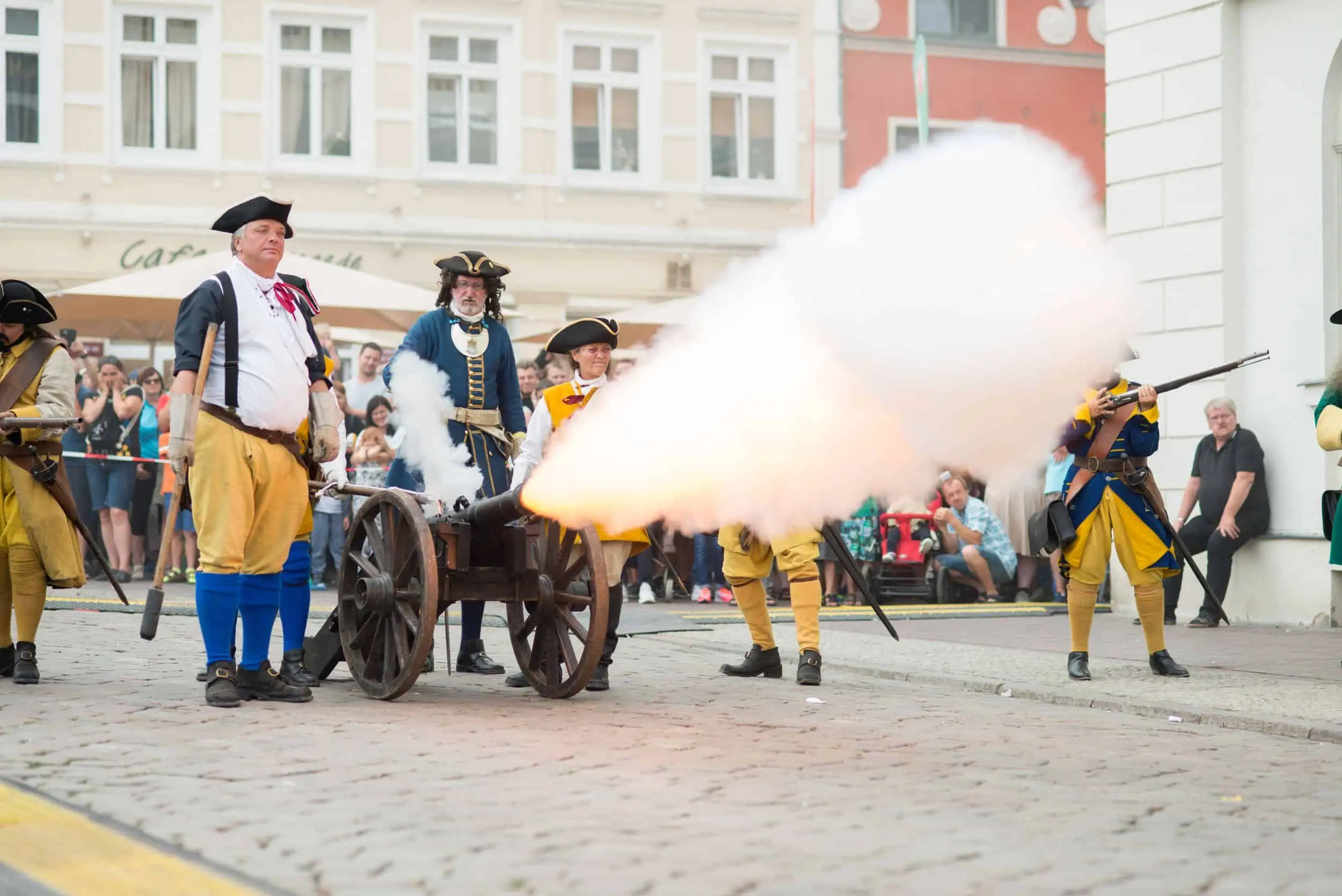 event-schwedenfest-wismar-foto-schweden-024 Historische Kanone feuert während einer Vorführung beim Schwedenfest Wismar, umgeben von Darstellern in Uniform.