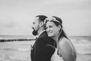 Brautpaar am Strand von Ahrenshoop in inniger Pose – Schwarz-Weiß-Aufnahme mit emotionalem Ausdruck, fotografiert von Hochzeitsfotograf Ahrenshoop.