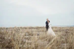 Brautpaar in eleganter Hochzeitskleidung steht eng um