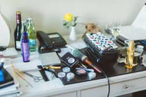 Frisiertisch mit Lockenwicklern, Make-up, Haarspray, Styling-Tools und Getränken – Vorbereitungen für das Hochzeitsstyling der Braut.