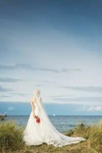 Eine Braut mit einem langen Schleier von hinten aufgenommen.