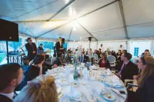 Hochzeitsgesellschaft bei festlichem Dinner im Zelt mit Livemusik und Reden beim Grand Hotel Heiligendamm.