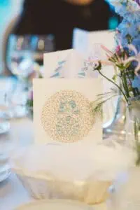 Stilvolle Tischkarten bei einer Hochzeit in Heiligendamm mit floraler Verzierung und Menükarte auf elegant gedecktem Tisch mit Blumenarrangement.