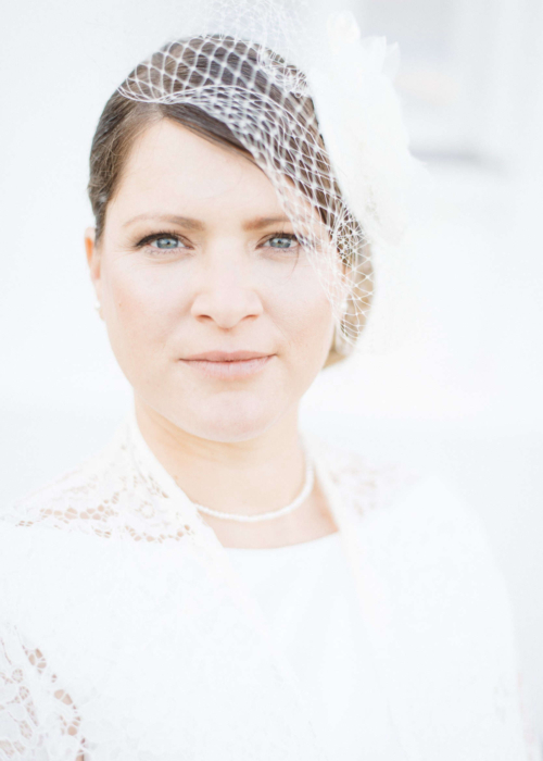 Zeitloses Brautporträt in High Key – Eleganz trifft Stil im GRand Hotel Heiligendamm Strahlende Braut in elegantem Hochzeitskleid vor dem Grand Hotel Heiligendamm.