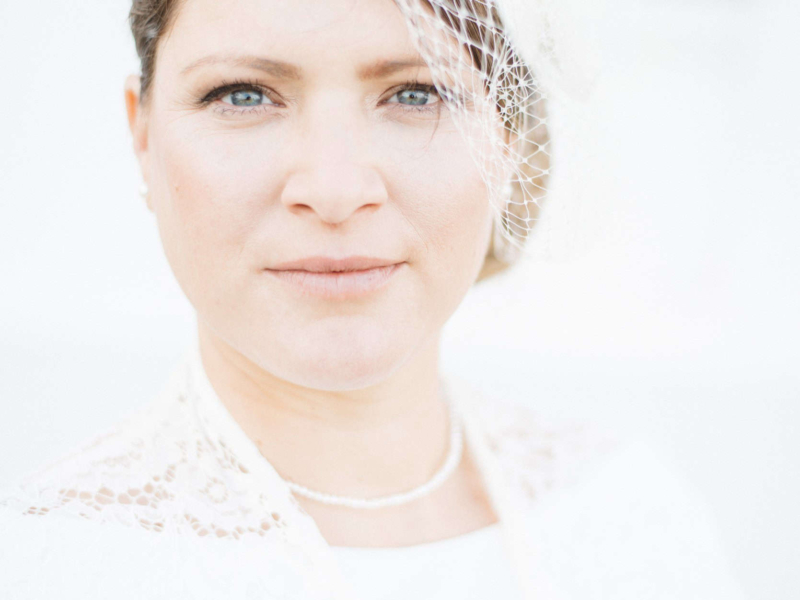Zeitloses Brautporträt in High Key – Eleganz trifft Stil im GRand Hotel Heiligendamm Strahlende Braut in elegantem Hochzeitskleid vor dem Grand Hotel Heiligendamm.
