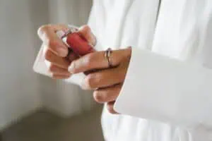 Detailaufnahme der Braut beim Öffnen eines Lippenstifts während des Getting Ready im Grand Hotel Heiligendamm.