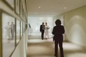 Vater begleitet seine Tochter, die Braut, durch einen eleganten Flur im Grand Hotel Heiligendamm zur standesamtlichen Trauung.