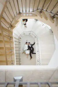 Hochzeitsfotograf in Heiligendamm fängt einzigartiges Bild eines Brautpaares auf einer spiralförmigen Treppe ein.