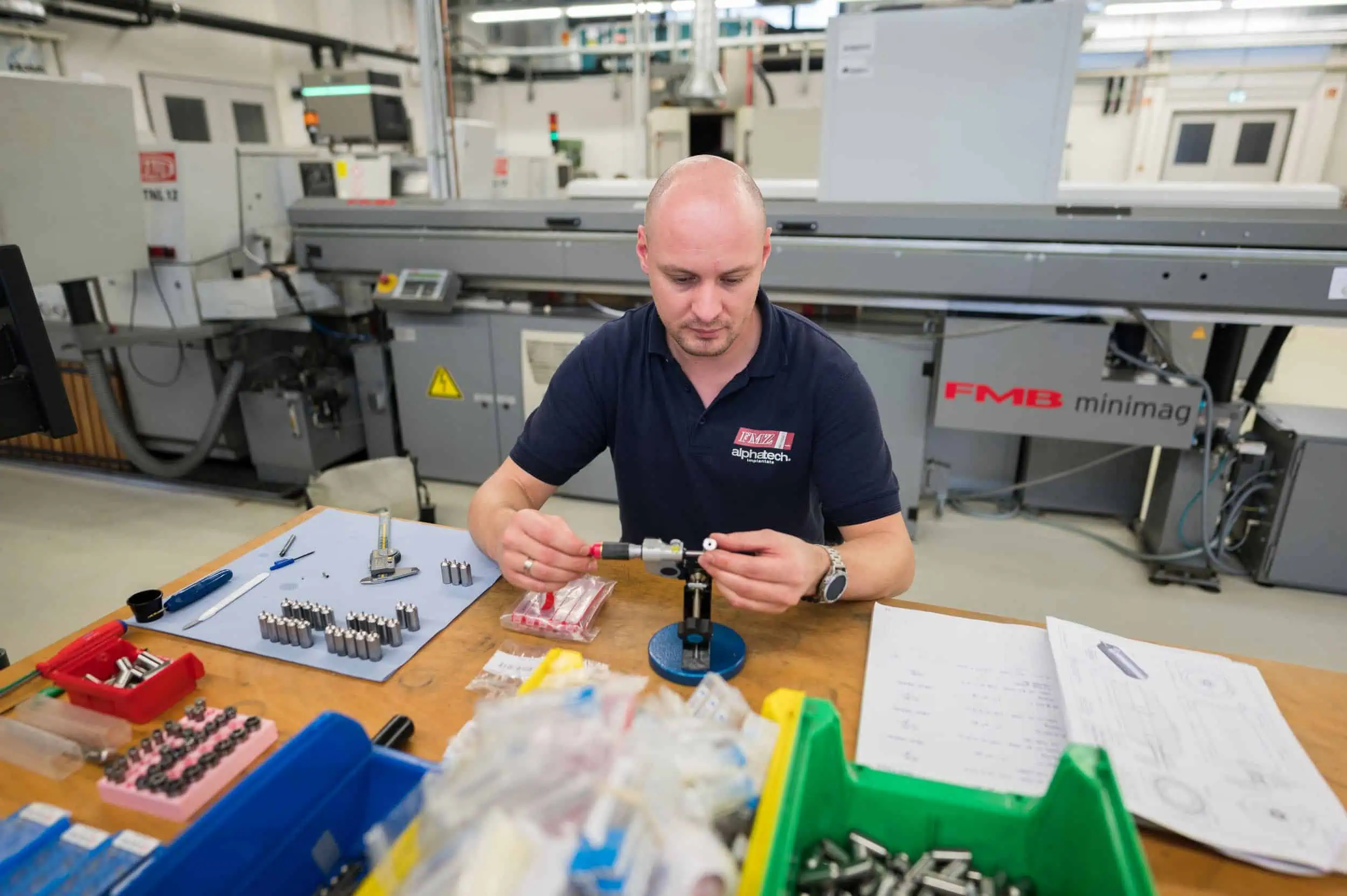 Martin Boerner Mitarbeiter prüft Bauteil mit Mikrometer in moderner Fertigung bei FMZ Rostock.
