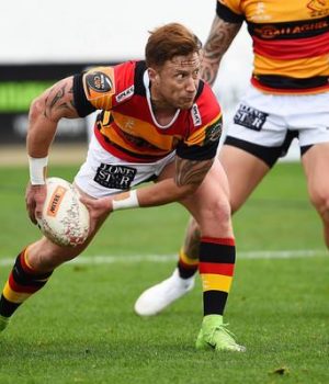 Dynamic rugby player sprinting with the ball during a match.