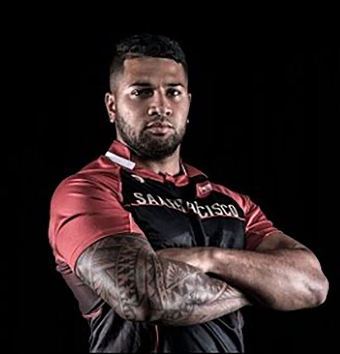Rugby player wearing San Francisco jersey with tattooed arm showing.
