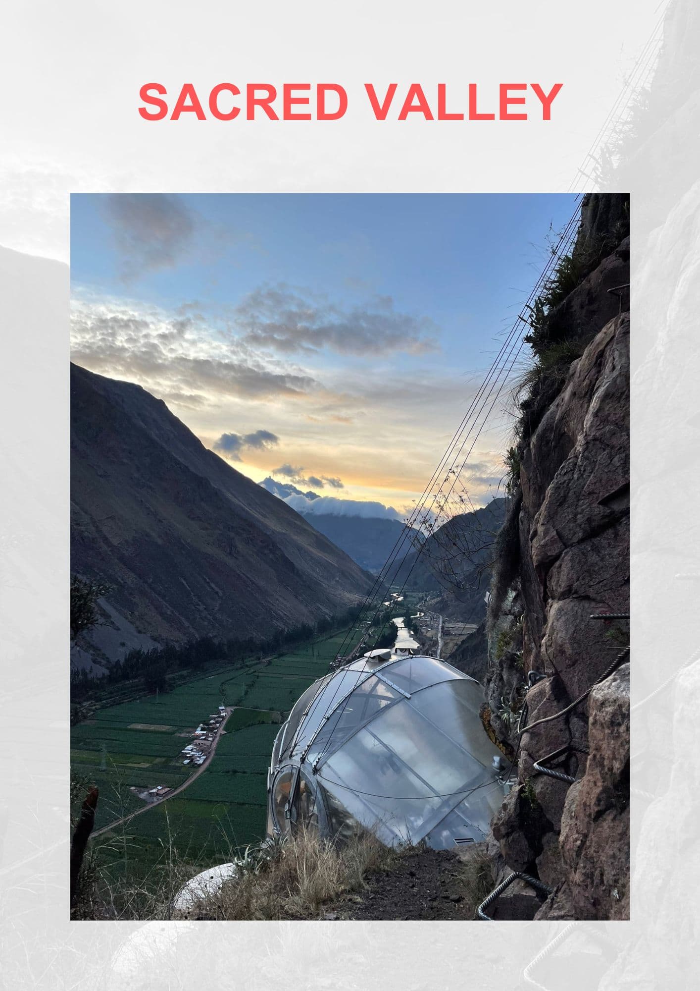A unique perspective of a transparent dome lodging on the side of a mountain, overlooking at the Sacred Valley in Peru with green fields and a river, under a sunset sky.