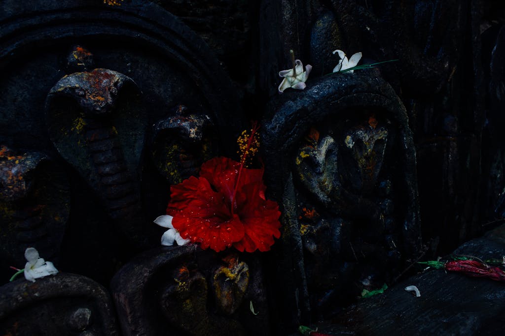 An intricately crafted snake statue draped in a vibrant tapestry of blooming blossoms, showcasing a harmonious blend of nature and artistry