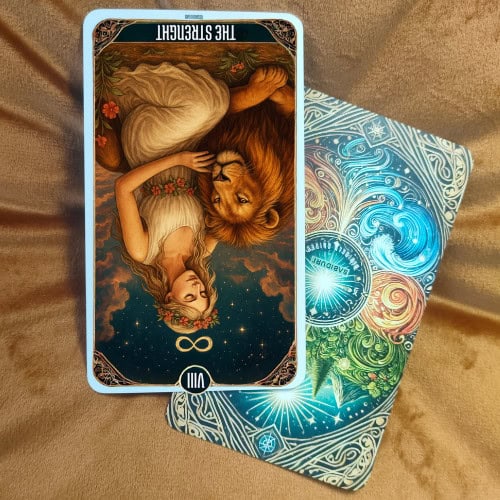 The Strength Tarot Card - 8 Major Arcana Tarot Card Meanings The Strength tarot card reversed, depicting the same figure and lion upside down, symbolizing inner weakness, self-doubt, or lack of control over emotions. The celestial background filled with stars, planetary symbols, and cosmic designs remains present, but the inversion emphasizes fear, insecurity, or emotional imbalance. This image represents the reversed meaning of The Strength tarot card as discussed in the blog post, focusing on vulnerability, overwhelm, and loss of inner strength.