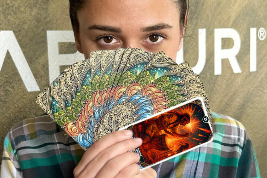 Oracle vs Tarot: Important Differences Explained Person holding a fan of tarot cards with a Wands card revealed, symbolizing intuition and the Suit of Wands tarot card meaning of inner fire and action.