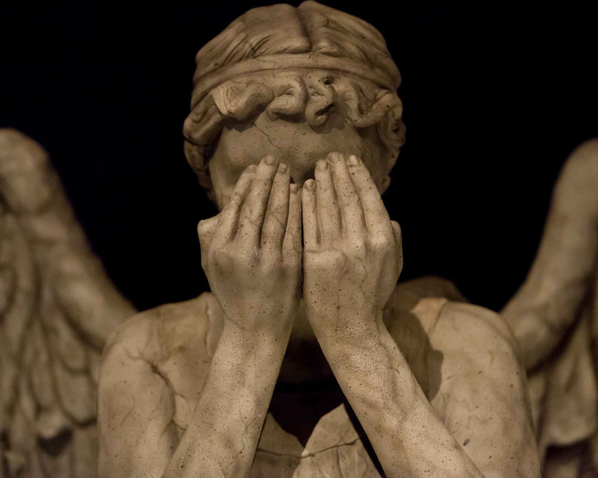 Stone angel statue covering its face, symbolizing introspection, change, and the deeper meaning behind angel number 010.