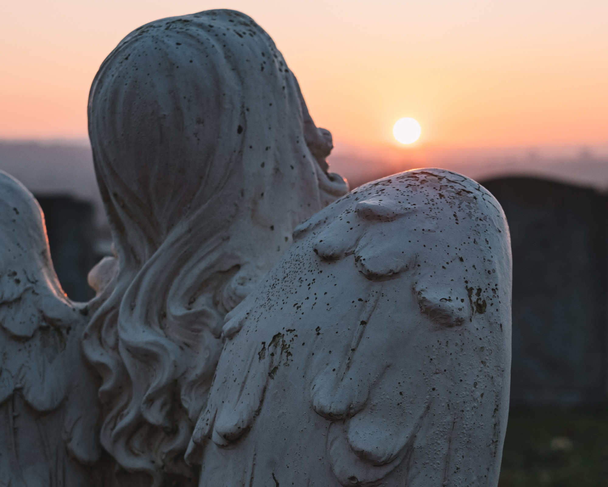 100 Angel Number 100 Angel statue overlooking a glowing sunset, representing spiritual protection and the deeper meaning of the 100 angel number.