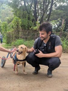 Elephant Nature Park: A Healing Place for Elephants and Humans Visitor meeting a rescued dog in a wheelchair at Elephant Nature Park animal sanctuary.
