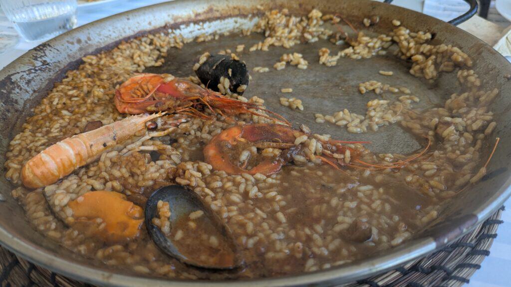 Spanish Food Culture: Discover Spain Through Its Traditional Cuisine A close-up view of a large paella pan containing Spanish seafood rice. The dish features whole prawns, mussels, shellfish, and tender rice cooked in a rich, savory broth. The rice is spread across the pan with seafood distributed throughout, highlighting one of Spain's most iconic traditional dishes.