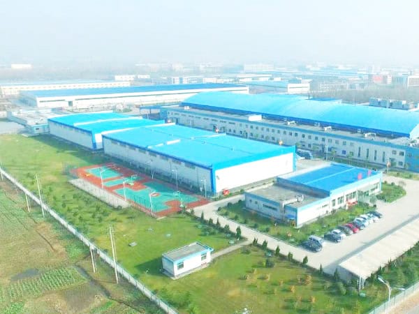1. Aerial view of Safeguard Systems Group's large manufacturing facilities with blue roofs, surrounded by green fields and sports courts, showcasing a leading Chinese industrial complex.