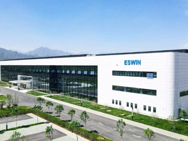 Advanced industrial building of ESWIN with modern design and large windows, set in a landscaped area with trees and parking lot, representing a leading electronics manufacturer in China.