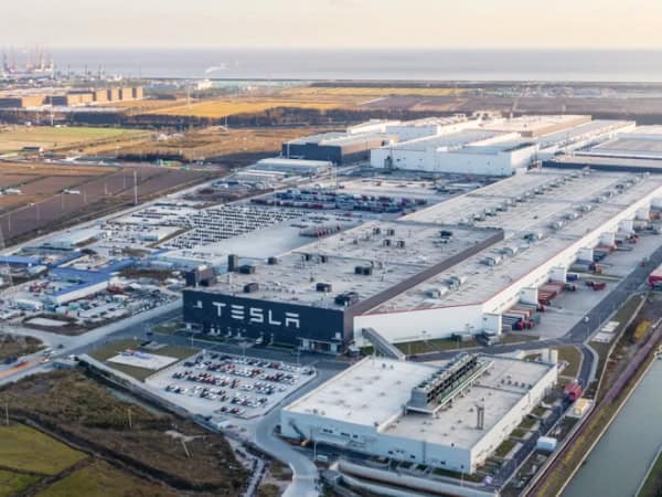 Tesla large manufacturing facility in China with extensive warehouse and logistics operations, viewed from aerial perspective.