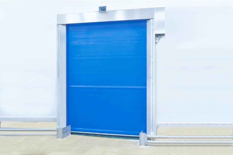 High-speed industrial roll-up door with blue fabric for commercial and industrial access control safety and security.