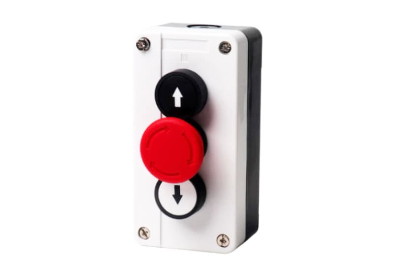 1. Industrial emergency stop button with black, red, and white colors, mounted on a white metal panel for safety and control systems.