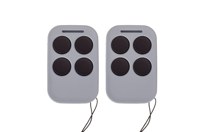 Remote control devices with four buttons, used for security or access systems. Compact design with black buttons and attached cords for easy operation. Ideal for controlling security doors or systems.