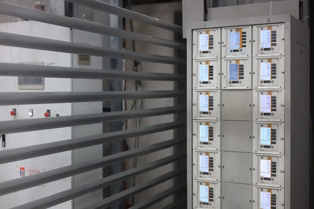 Metal door profiles moving through an automatic white powder coating line