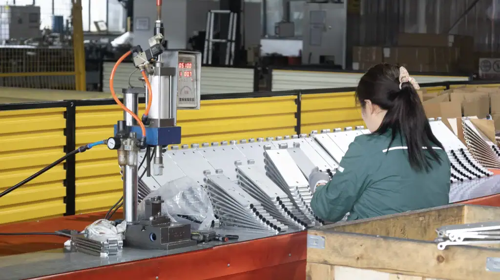 Worker producing metal hinge components for industrial and garage doors