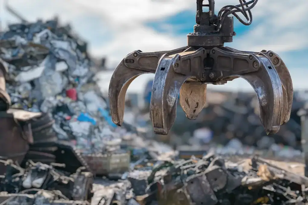 Industrial material handler sorting scrap metal for recycling