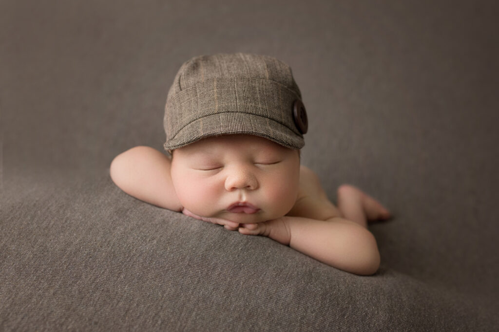 newborn baby boy face forward in drivers cap