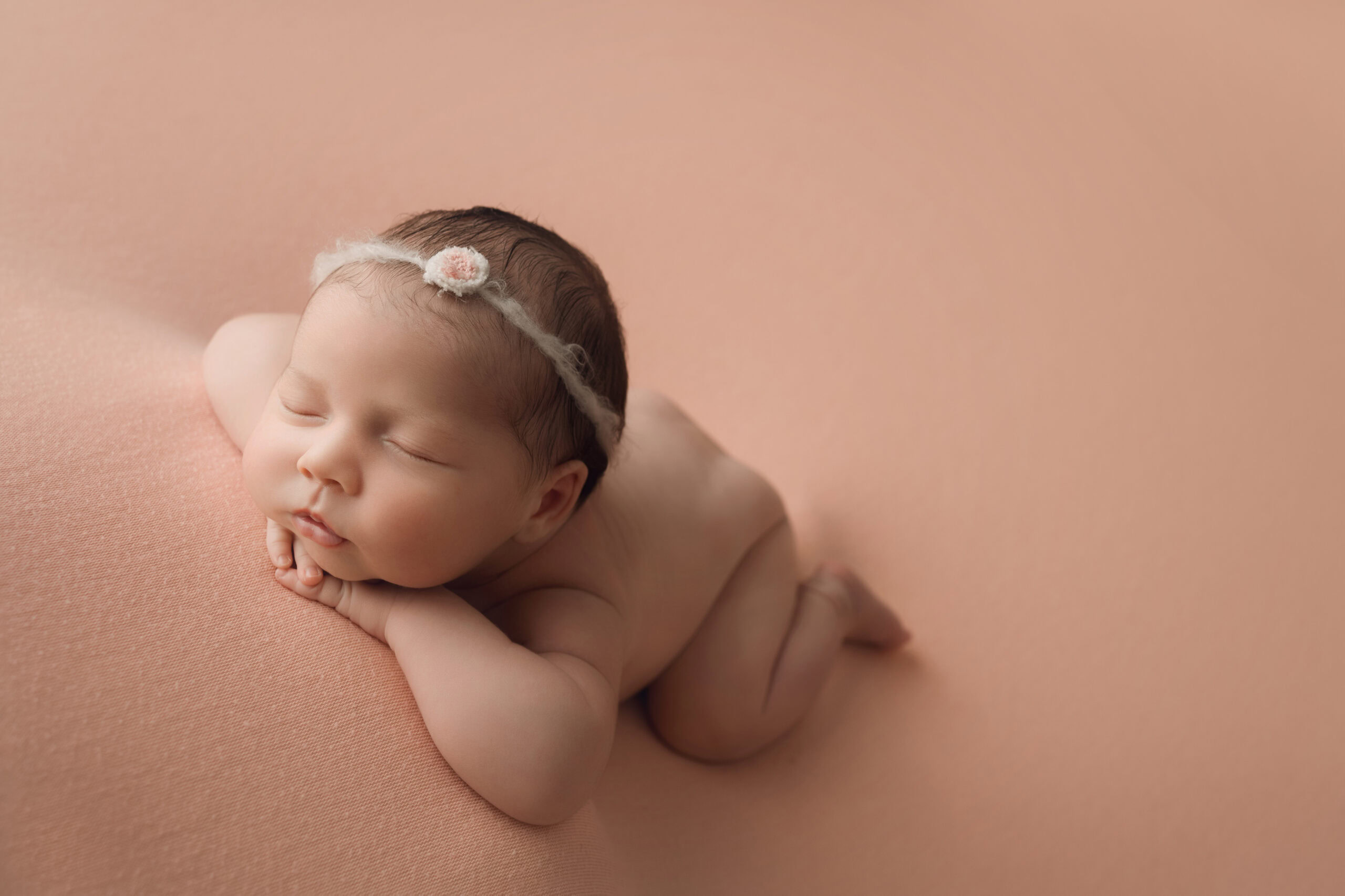 ### Newborn baby girl face forward on pink blanket