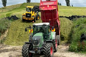 Sanson Agriculture tractor loading gravel on countryside farm site.