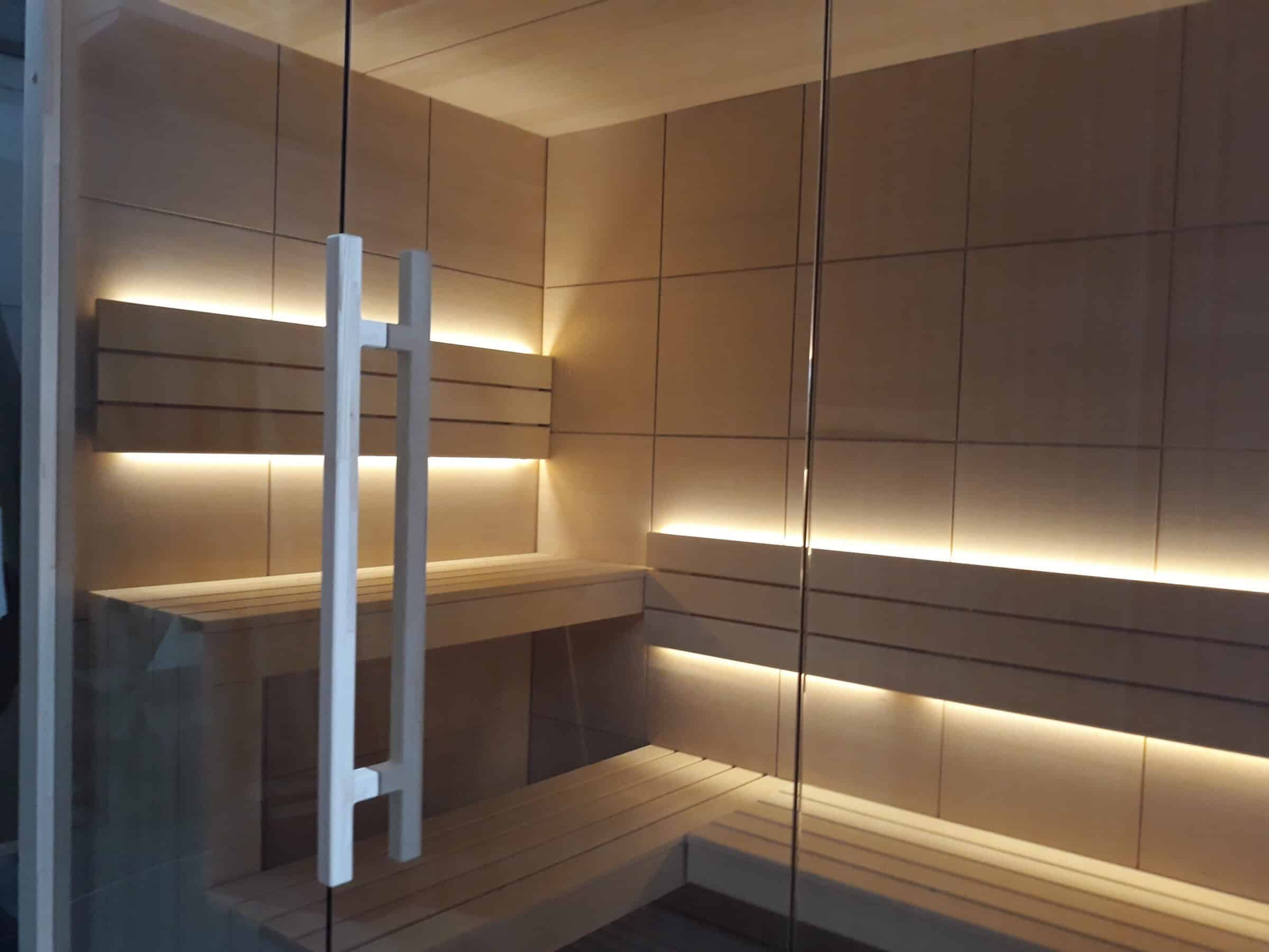 Relaxing modern sauna interior with wooden benches and ambient lighting.
