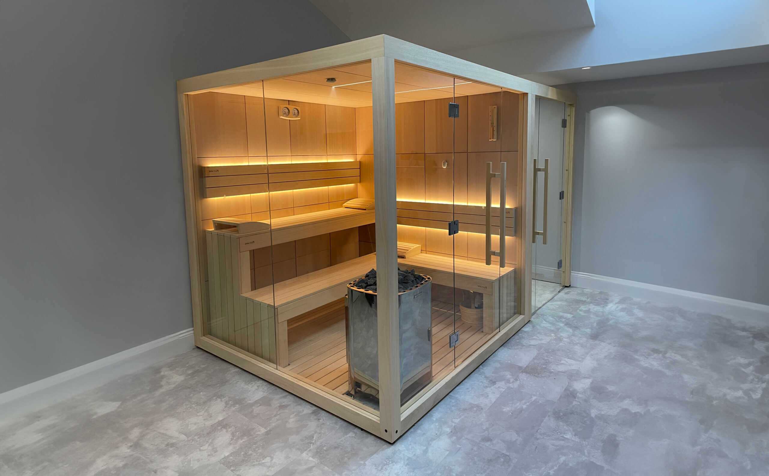 A detailed wooden infrared sauna cabin with glass doors, featuring modern lighting and comfortable seating.