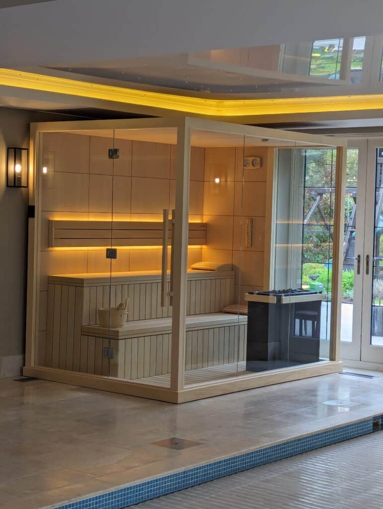 indoor sauna cabin with glass doors and warm lighting.
