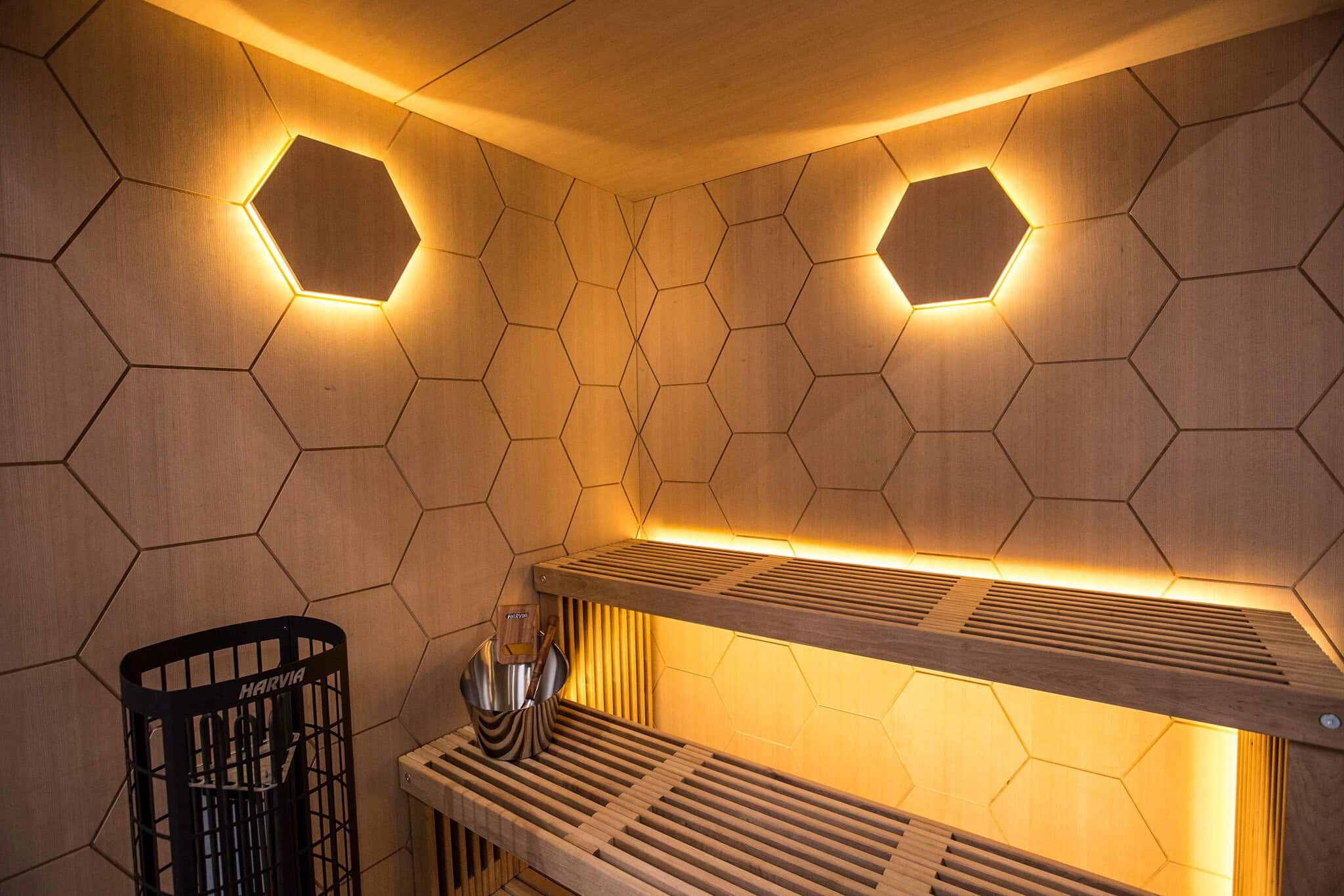 Relaxing infrared sauna with hexagonal wall panels and warm ambient lighting.