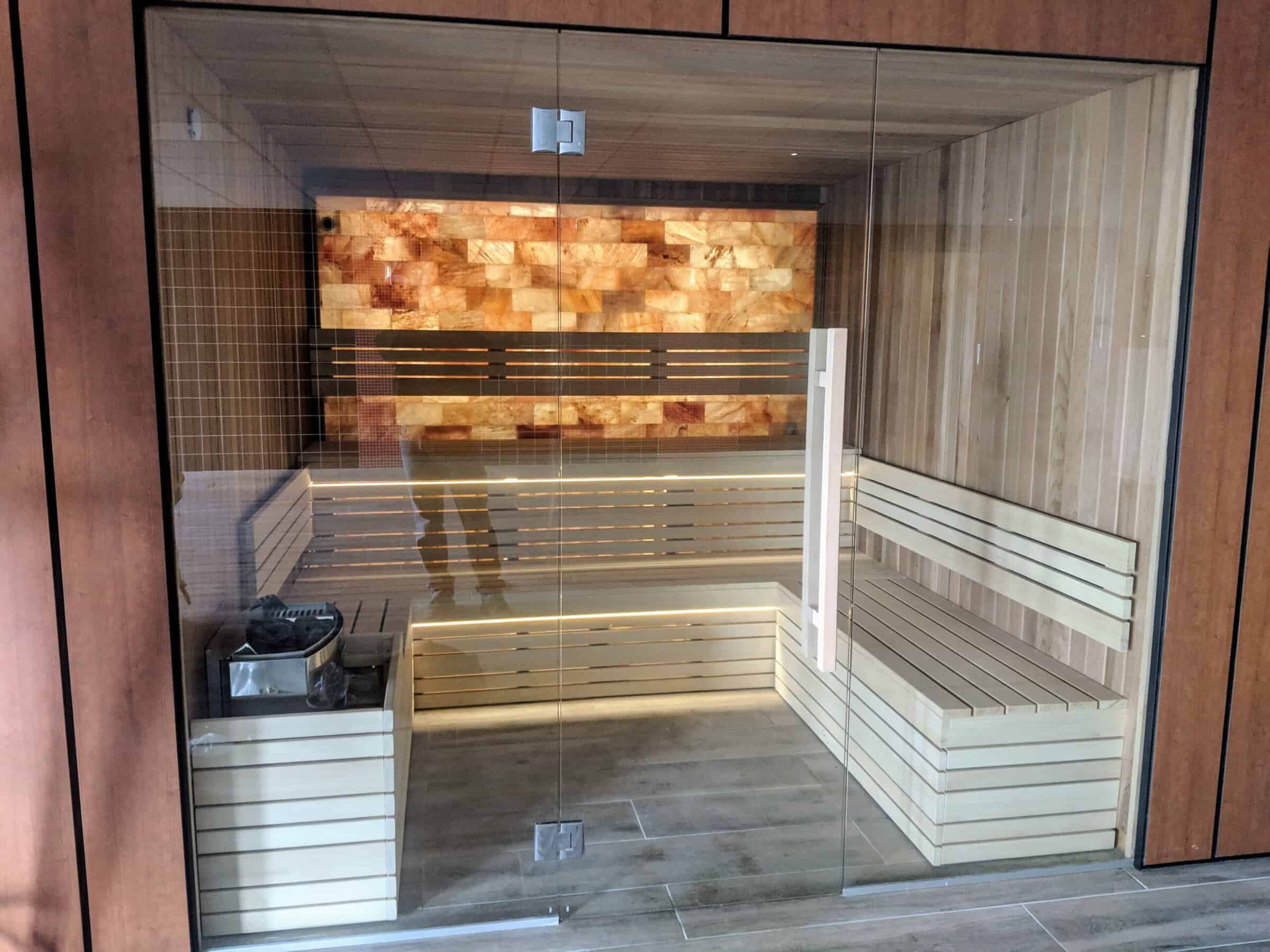 Relaxing wooden sauna with glass door and interior benches, designed for home wellness and relaxation. Perfect for heat therapy and stress relief in a modern setting.
