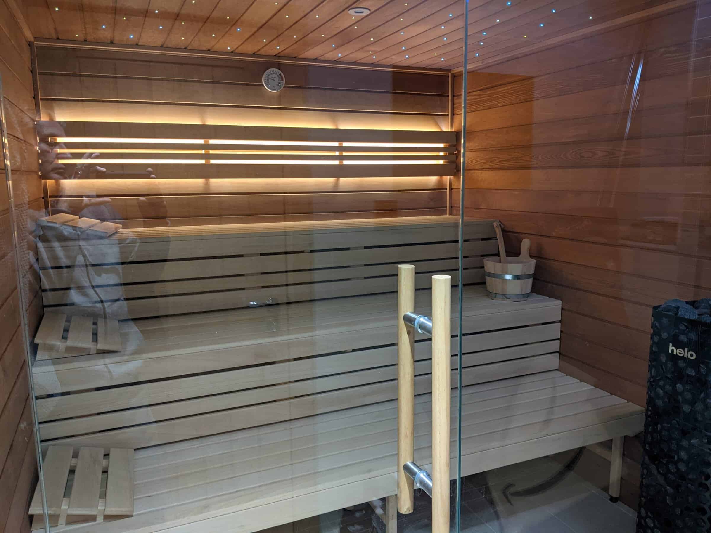 wooden sauna interior with bench seating and modern lighting