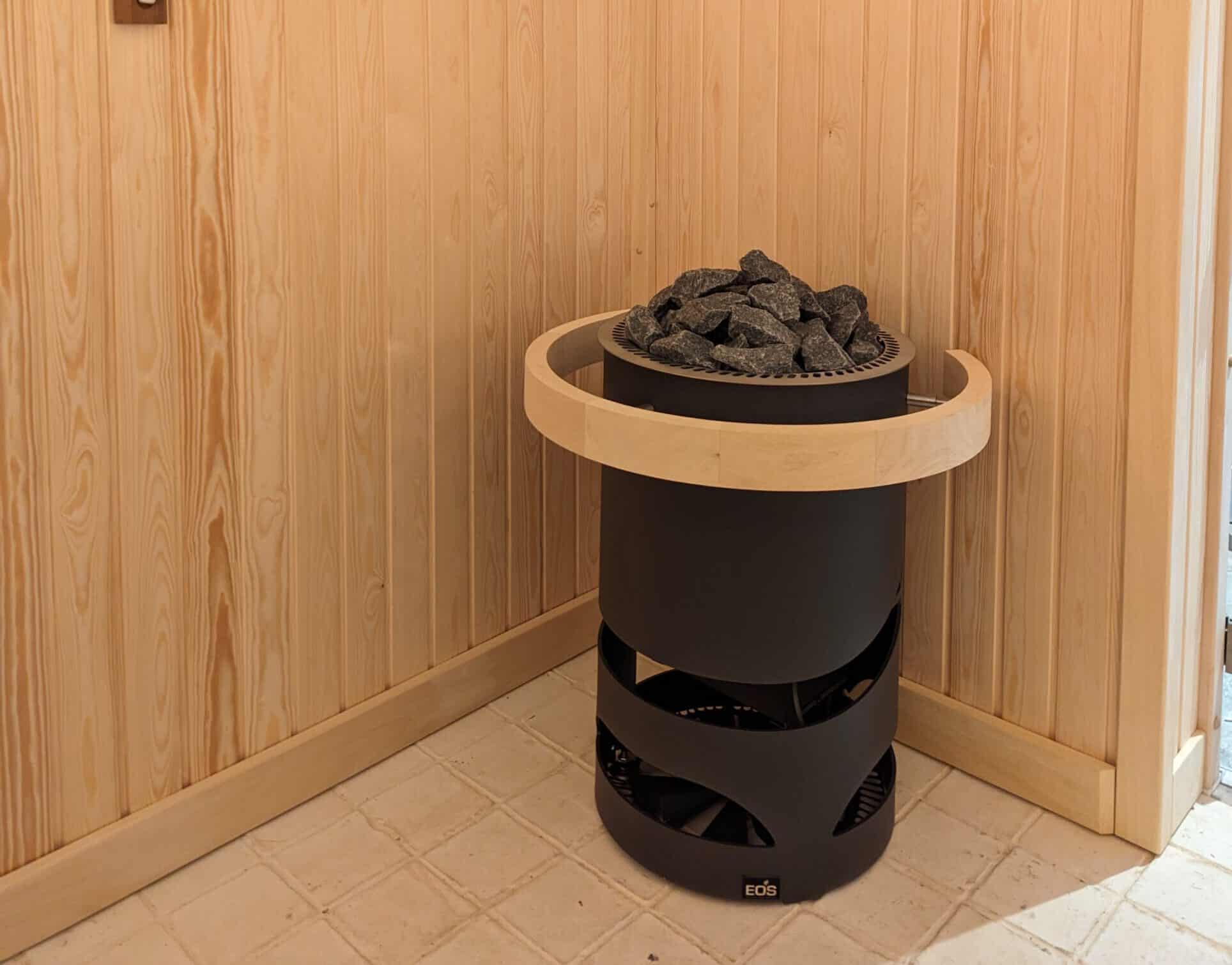 Sauna stove with rocks inside a wooden sauna room.
