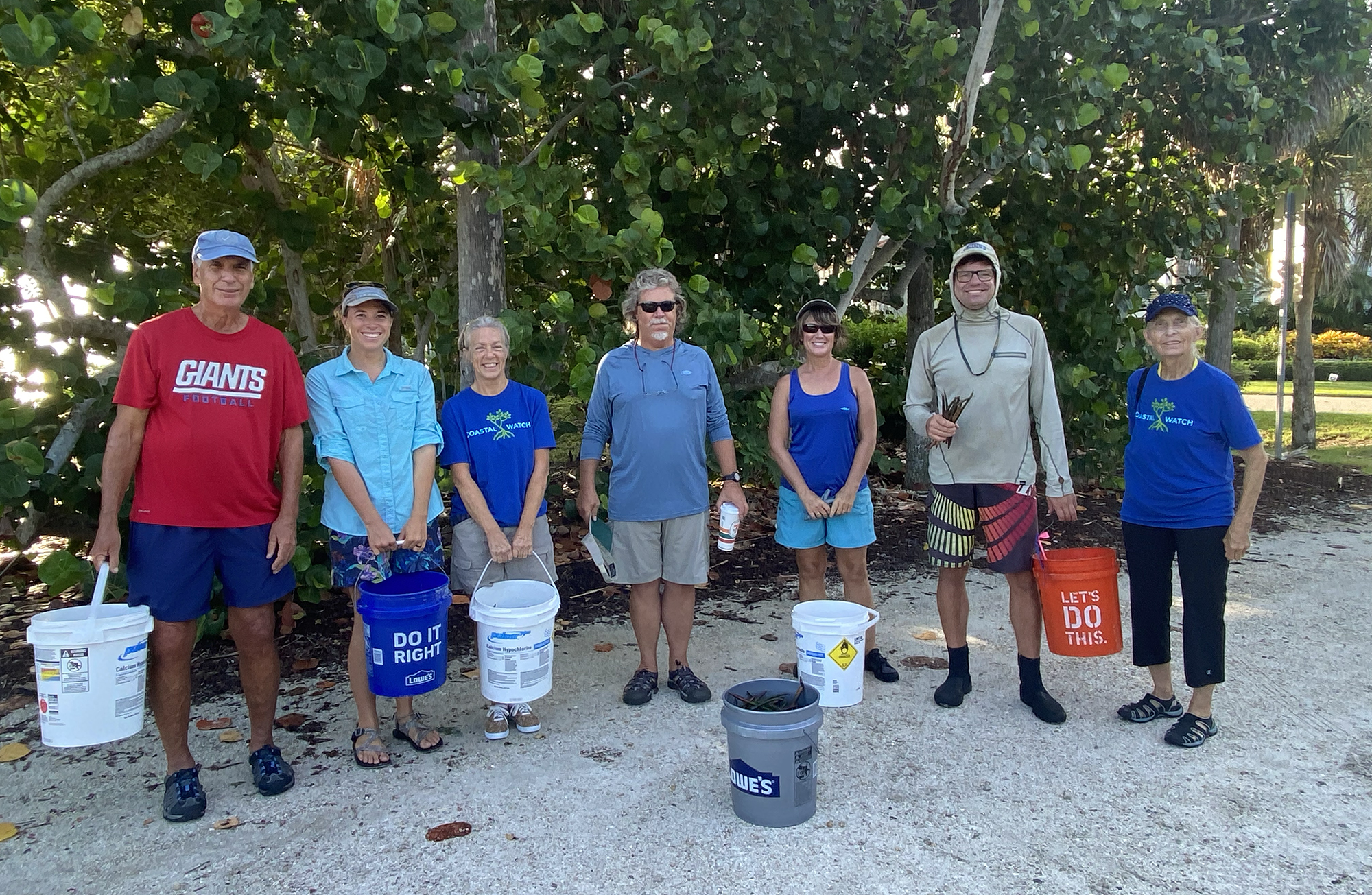 Image of people standing with buckets and smiling