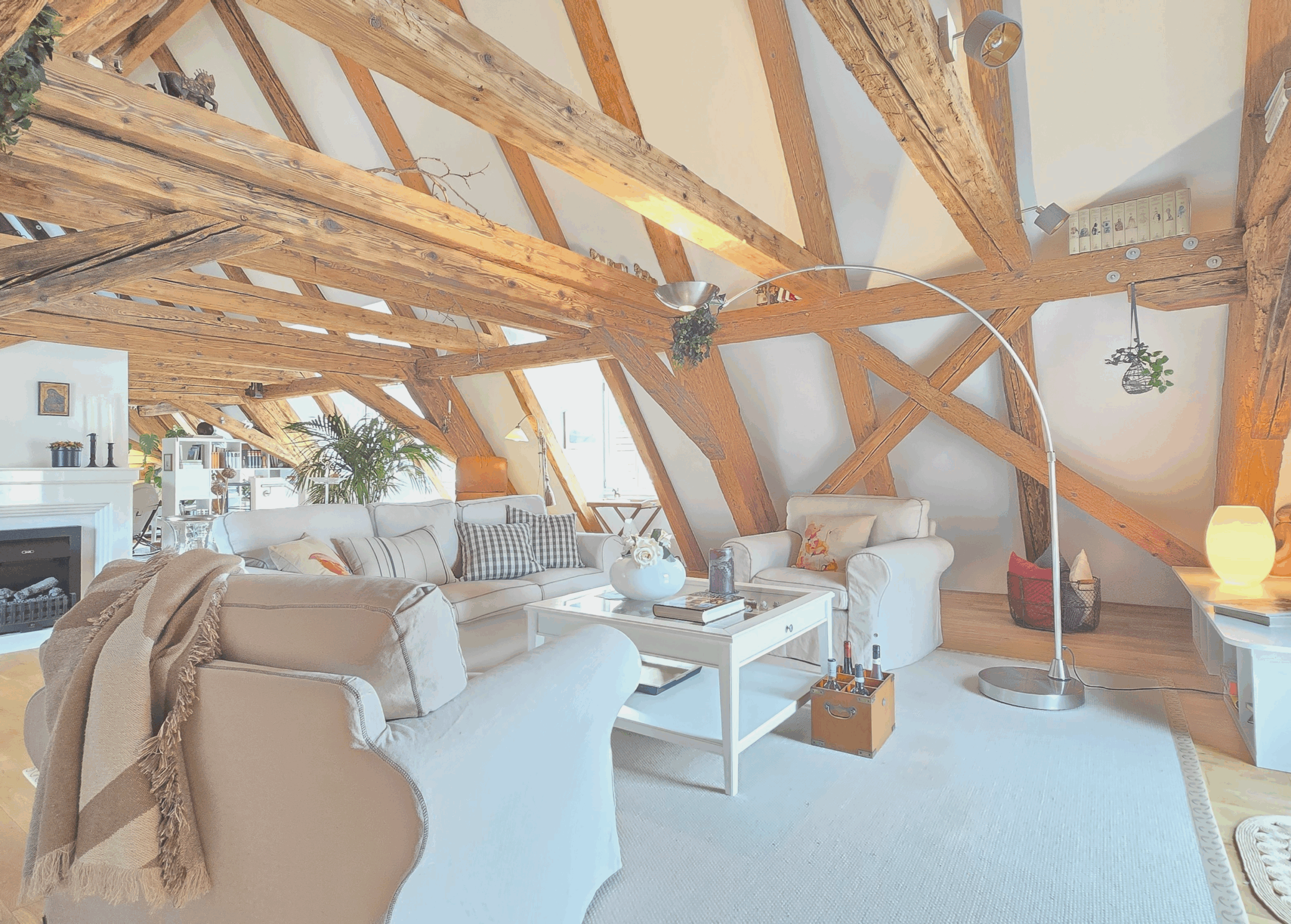 Helles Wohnzimmer mit Holzbalken, bequemen Sofas und stilvoller Dekoration.