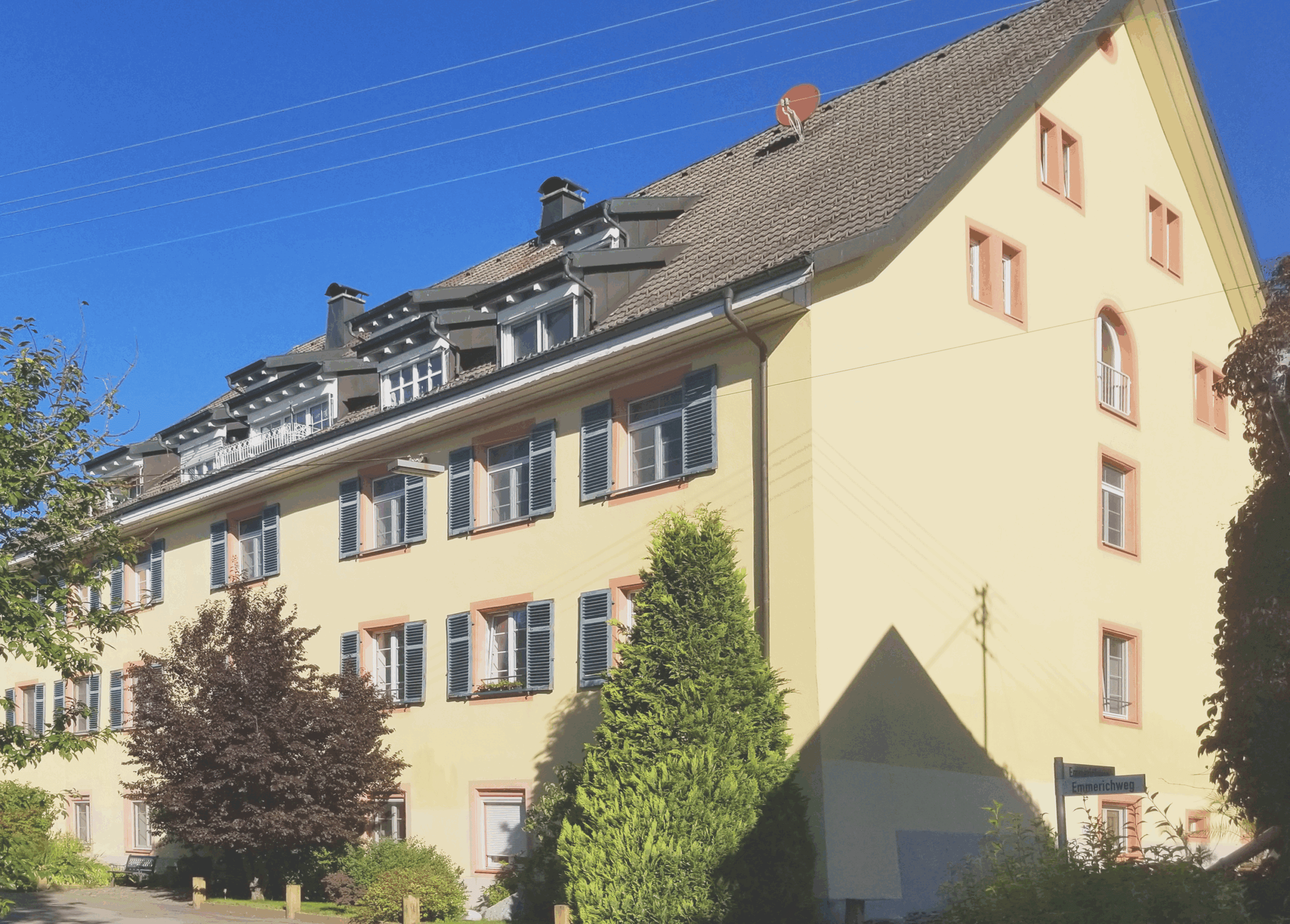 Mehrfamilienhaus in Deutschland mit gepflegter Fassade und grünen Gärten.