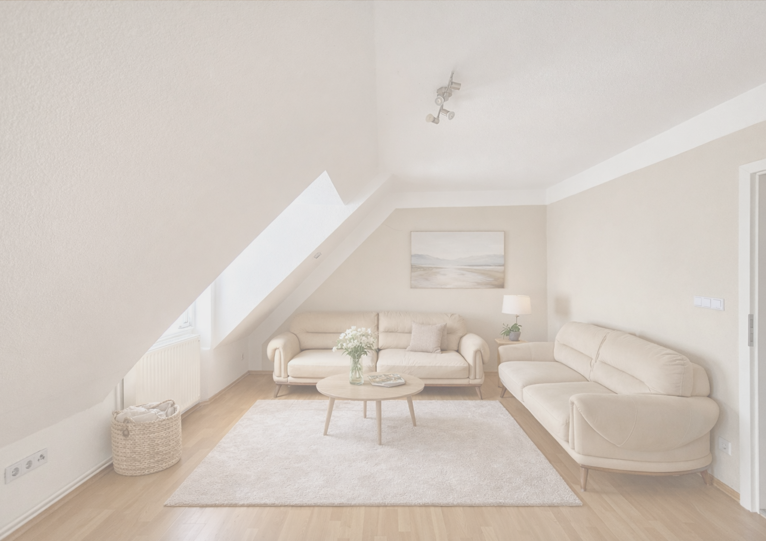Helles Wohnzimmer mit Sofa, Sessel und Dekoration im Dachgeschoss.