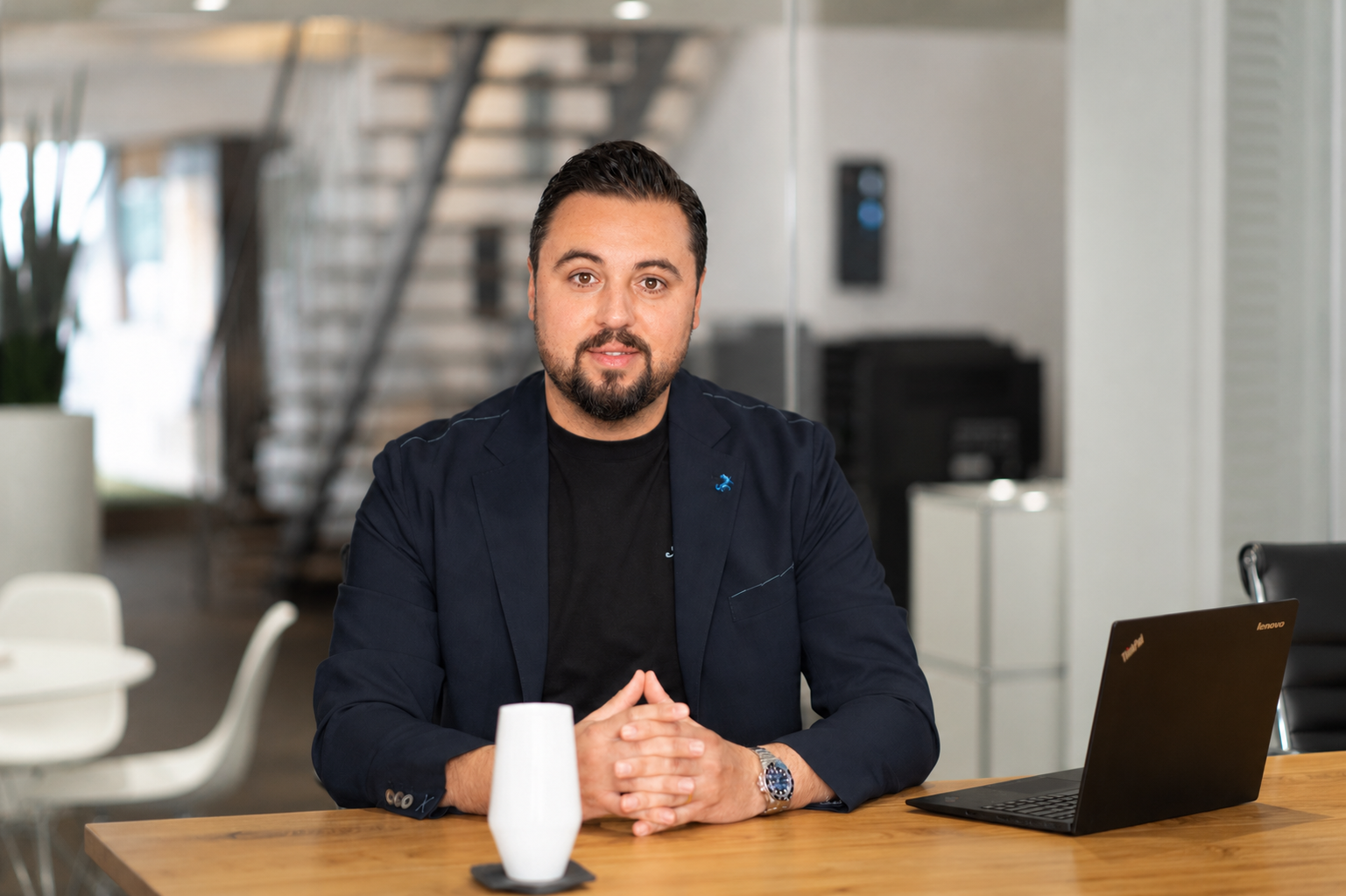 Geschäftsmann bei Schreibtisch mit Laptop und Vase in Büro.